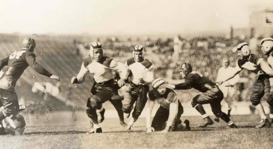 Black and white game action photo of Bohn Hilliard making the touchdown that defeated Notre Dame on Oct 6th 1934 in Notre Dame stadium; final score Texas 7 - Notre Dame 6.