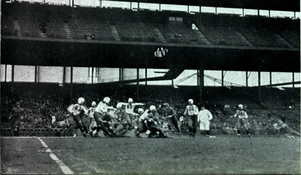 Black and white, distant blurry image of game action in football in 1933