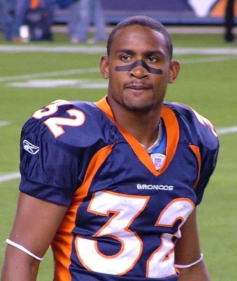 Color photo of Dre Bly in a blue Denver Broncos number 32 jersey with his helmet off.