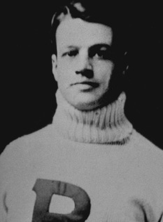 Publicity photo head shot of Ed Hart posing in his white Princeton sweater