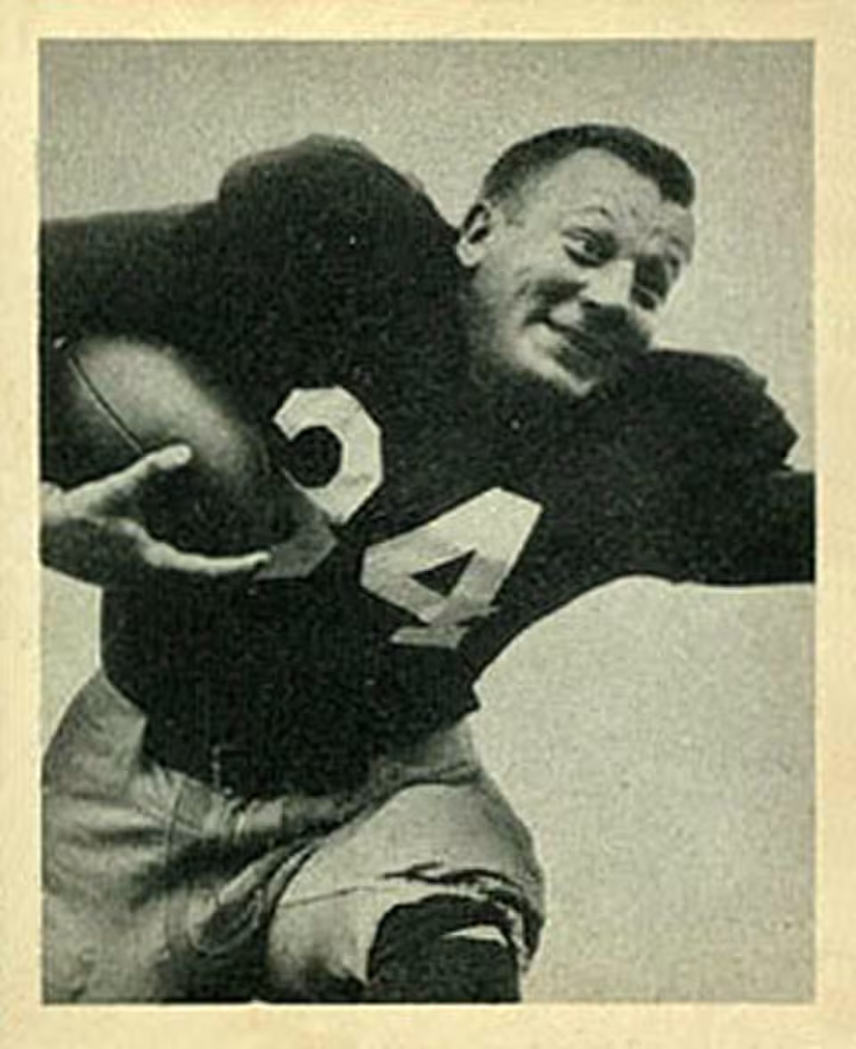 Vintage black and white publicty phot of Pat Harder in a dark uniform jersey 34 carrying a football