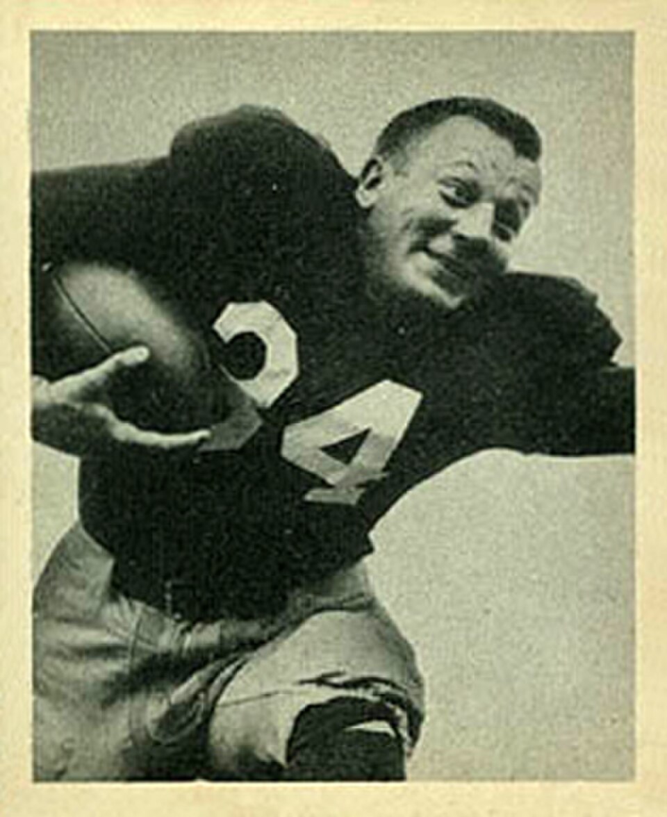 Vintage black and white publicty phot of Pat Harder in a dark uniform jersey 34 carrying a football