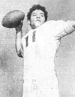 Vintage black and white newspaper publicity photo of American football player Herman Wedemeyer, in his all white St. Mary's Gaels football uniform jersey 11, posing to throw a pass without a helmet on.