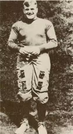 Vintage black and white publicity photo pof West Virginia Mountaineer Ira Rodgers in full early twentieth century football uniform.