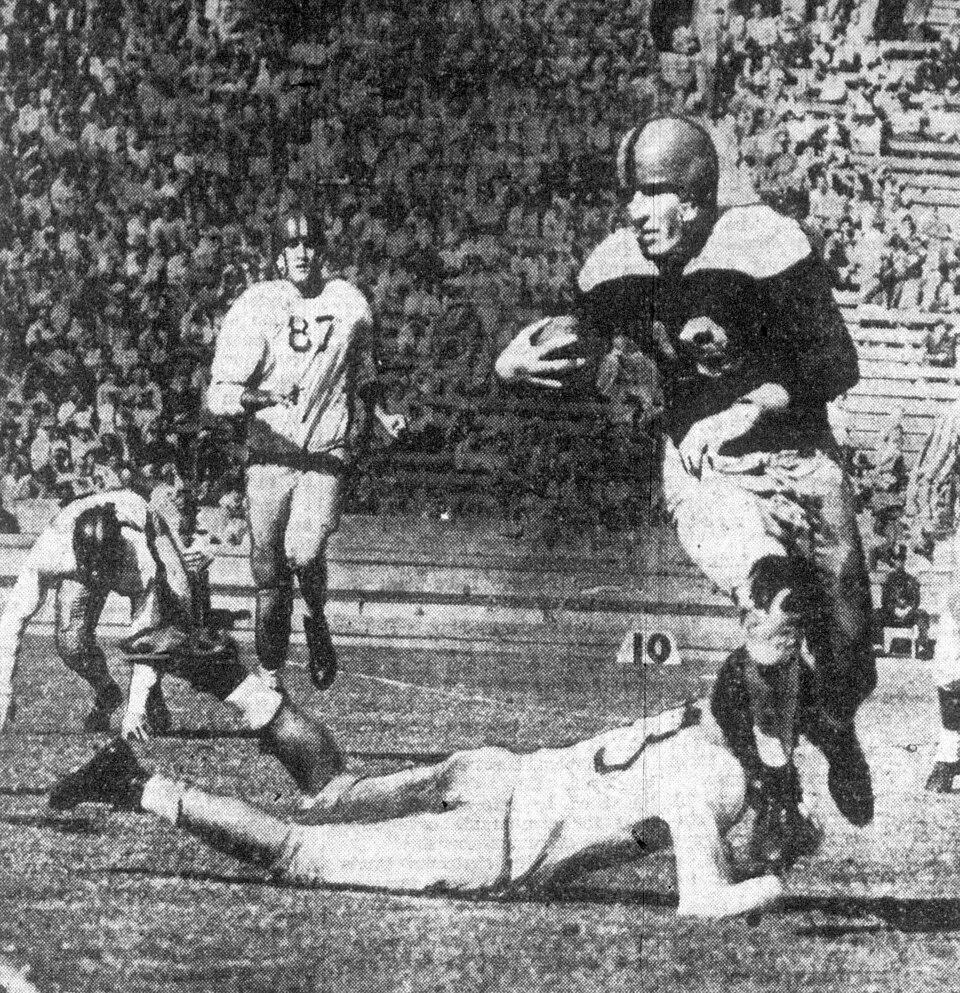 vintage 1943 newspaper game action photo of Pacific Tigers player Johnny Podesto (right, with ball) rushes the ball down field after avoiding USC Trojans defender Howard Callanan during a game on October 23, 1943 at Los Angeles Memorial Coliseum in Los Angeles, California.