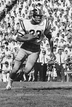Black and white game action photograph of Johnny Roland in full Missouri Tigers uniform, jersey 23, against Cal in 1962