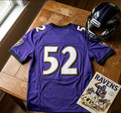 Vintage Baltimore Ravens #52 football jersey as seen in Lewis_52.jpg. Ravens purple mesh with white, black, and gold shadowed block numbers. Includes a black Ravens helmet and a gameday program for historical NFL research on Hall of Fame linebacker Ray Lewis for Pigskin Dispatch archives.