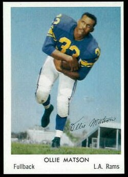 Color A 1959 promotional image of Los Angeles Rams player Ollie Matson in a blue Rams uniform, without helmet posing a football move.