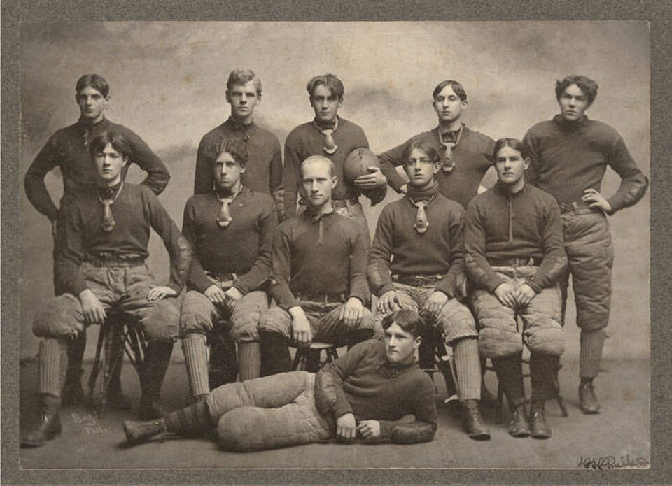 Vintage black and white team photo of memmbers in football uniform of University of Washington football team, ca 1903.