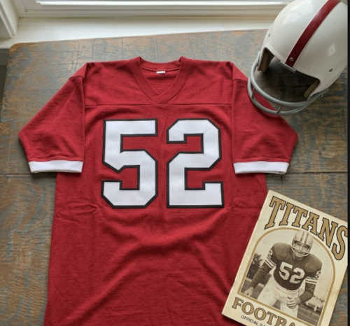 Vintage Westminster #52 football jersey. Scarlet mesh with white and black shadowed block numbers and triple-striped sleeves.