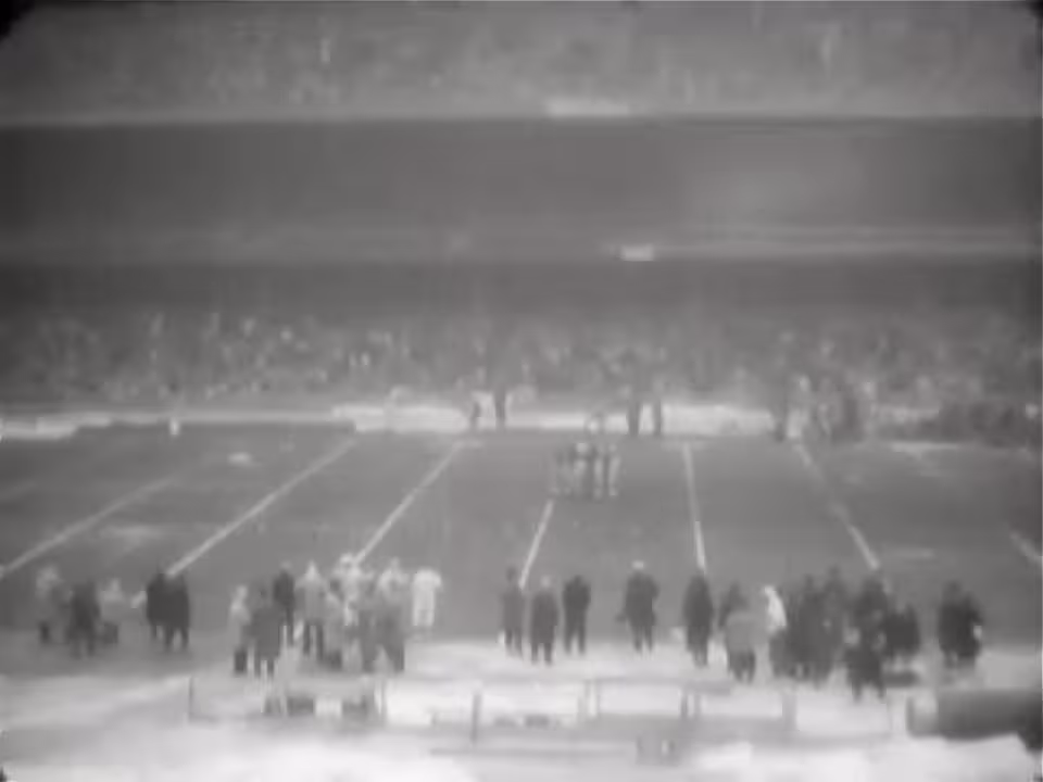 blurred black and white photo from the press box of a packed hosue at Yankee Stadium during a New York Giants - Cleveland Browns game in 1961.