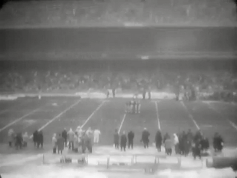 blurred black and white photo from the press box of a packed hosue at Yankee Stadium during a New York Giants - Cleveland Browns game in 1961.