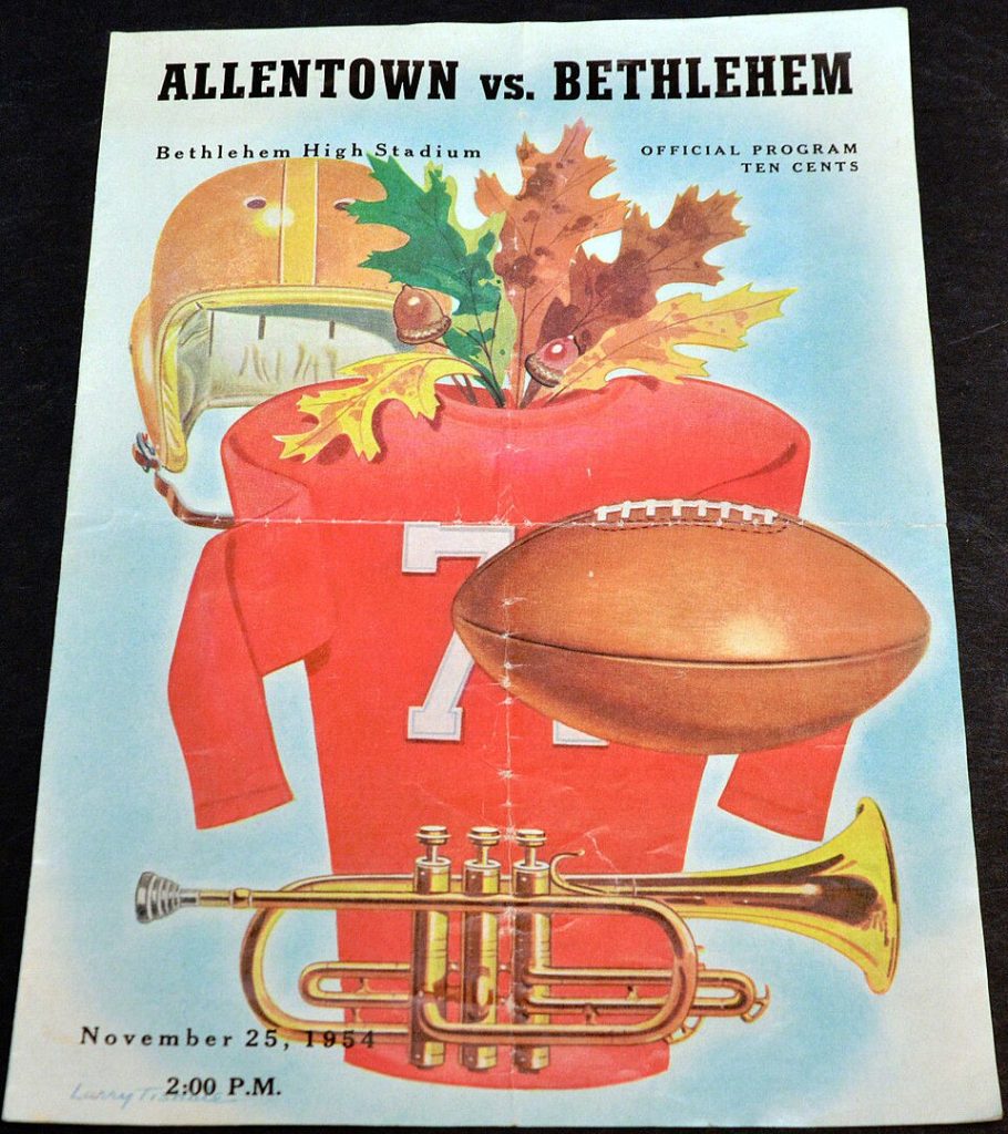 full color artist rendering of a red football jersey, 1950s era helmet, football, and a trumpet for the 1954 Allentown vs Bethlehem High School Football Program - Bethlehem PA