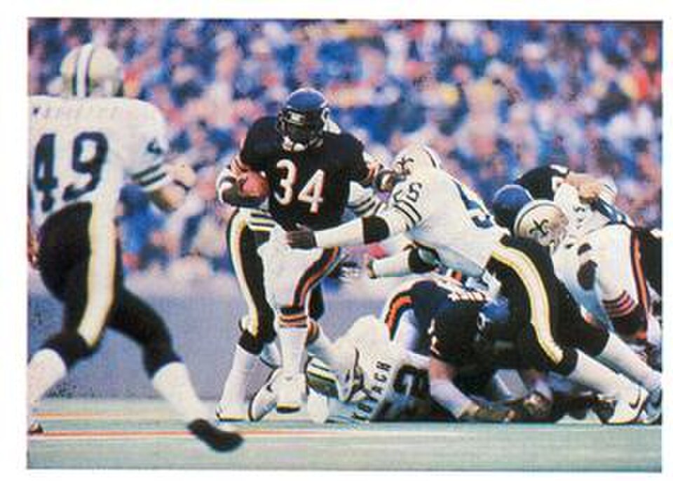 Full color game action image of Chicago Bears RB number 34 Walter Payton breaking tackles during a run against the New Orleans Saints.