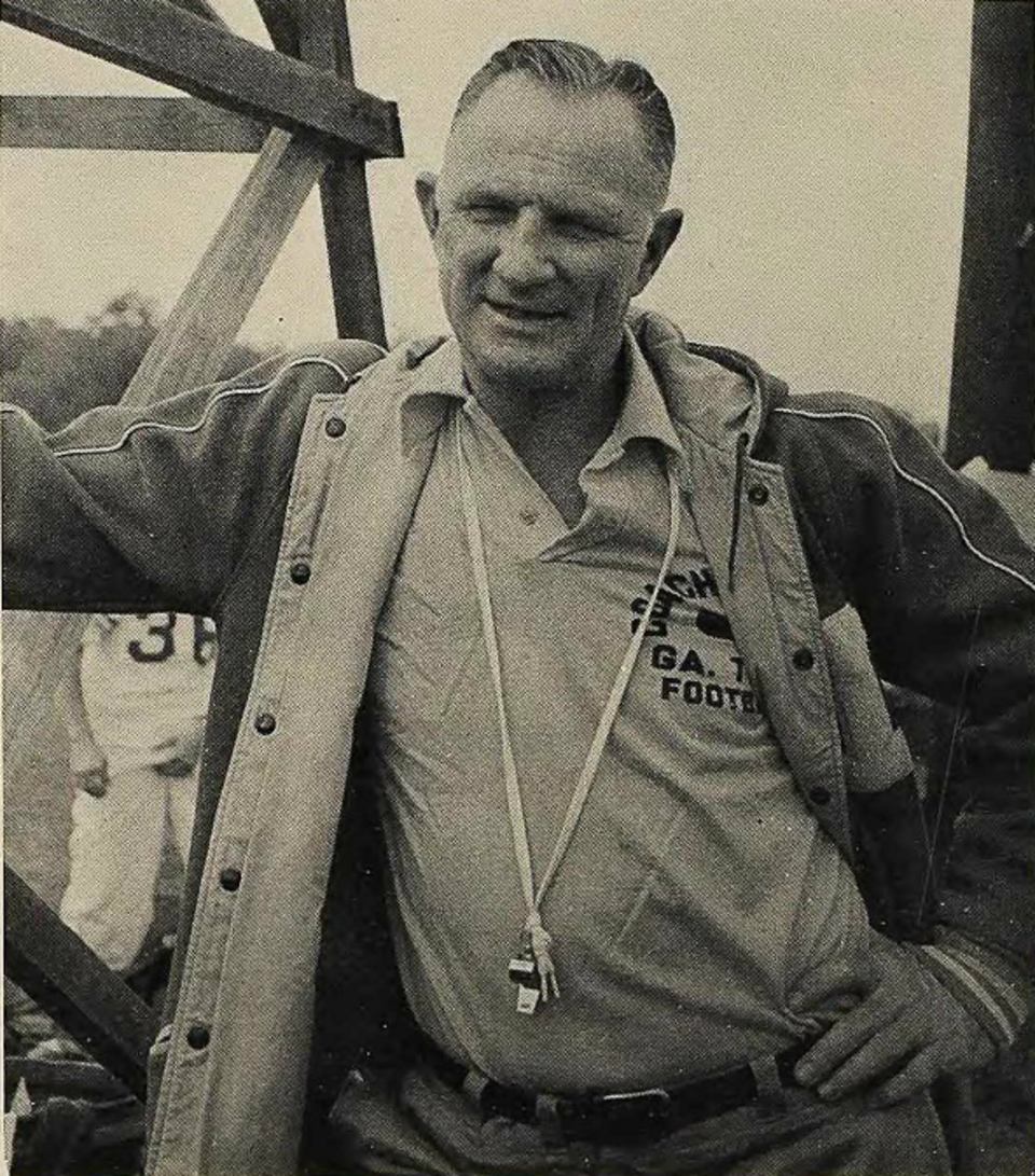 Vintage black and white photo of Bobby Dodd posing on the football practice field.