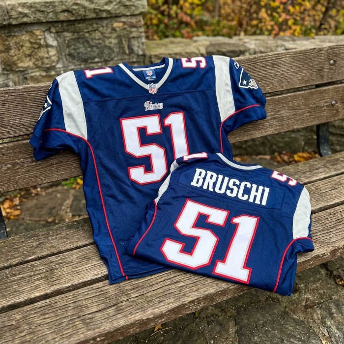 Full color created AI result ofan image of a New England NFL jersey number 51 from the 2000 season sitting on a wooden bench