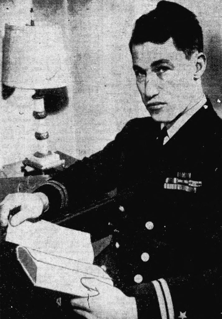 Vintage, grainy, black and white newspaper image of White in 1945 wearing a military dress uniform, sitting posed reading a book.