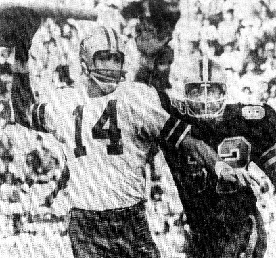 grainy black and white newspaper game action shot of 1969 - Dallas Cowboys quarterback Craig Morton (left) getting ready to throw the ball as New Orleans Saints linebacker Johnny Brewer (right) goes for the sack.