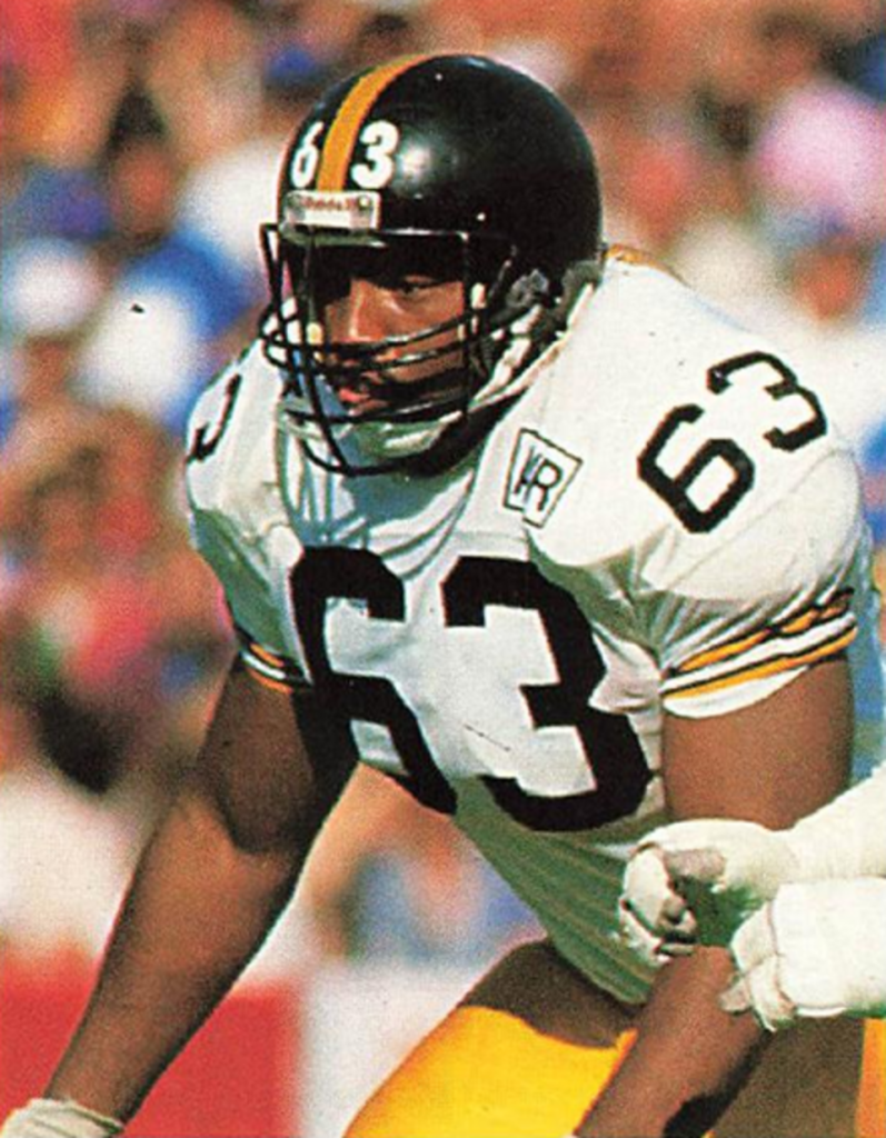Full color game action photo of Dermontti Dawson in 1988 wearing his Steelers white number 63 jersey