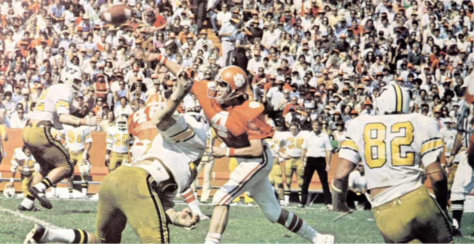 Full color photo pf American football game action as Clemson's Steve Fuller passes under pressure from the Wofford defense