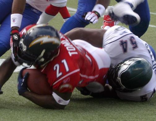 Color image of L. Tomlinson being tackled during the 2006 NFL Pro Bowl cropped