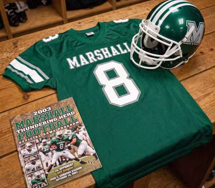 AI-generated green Marshall jersey 8 on a wooden table with a green helmet and period example of a program