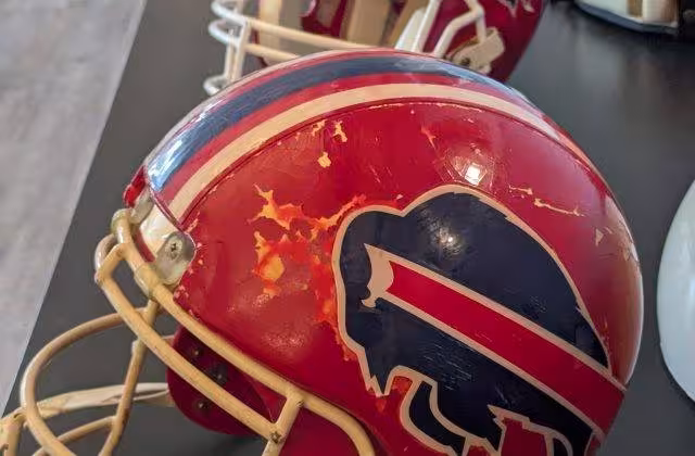 Color image of Mark Kelso's 1992 red Buffalo Bills Helmet with the ProCap protector on it. Taken by Darin Hayes WNY PFRA Conference April 2026