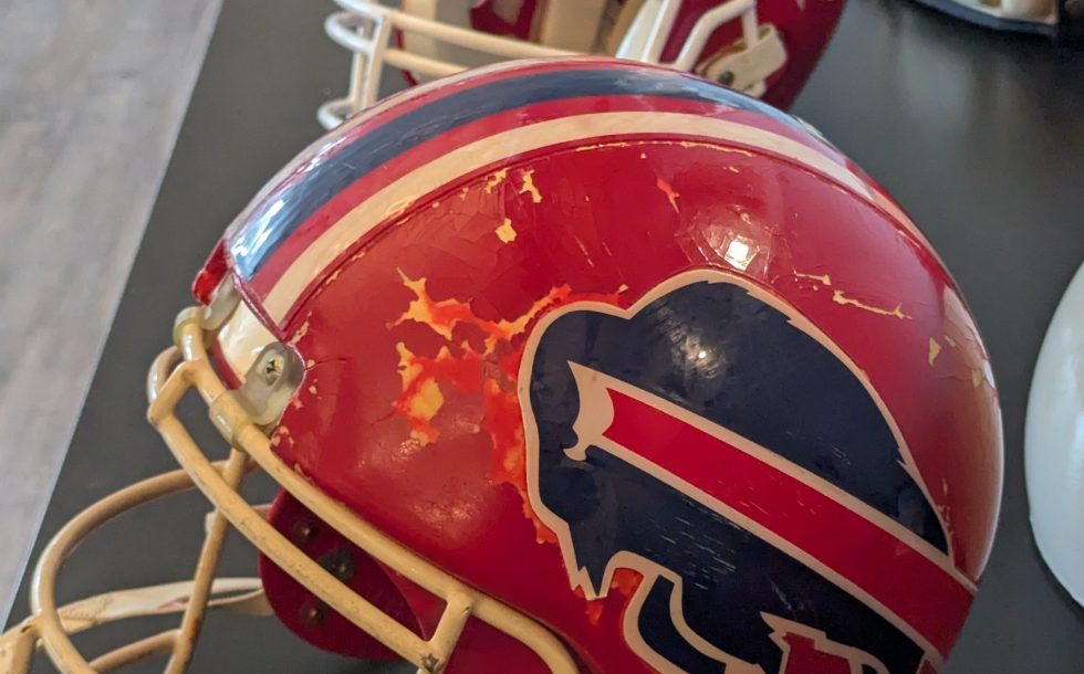 Color image of Mark Kelso's 1992 red Buffalo Bills Helmet with the ProCap protector on it. Taken by Darin Hayes WNY PFRA Conference April 2026