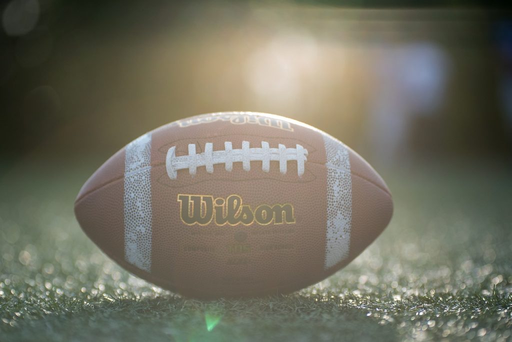 Full color image of a brown Wilson leather football with white stripes