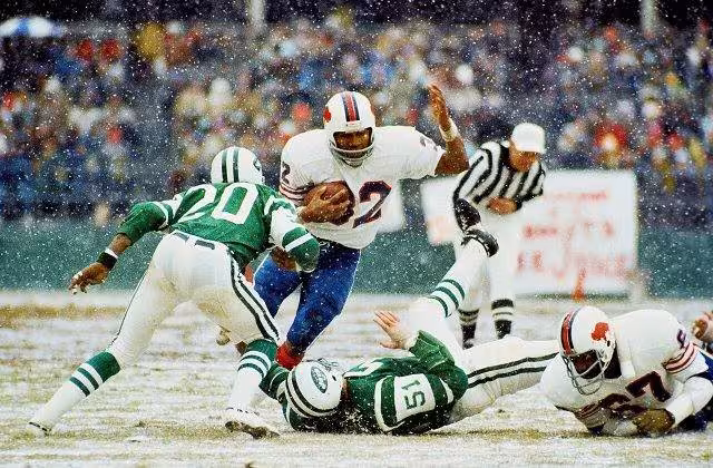 Full color game action photo of Simpson breaking the NFL's single-season rushing record in 1973