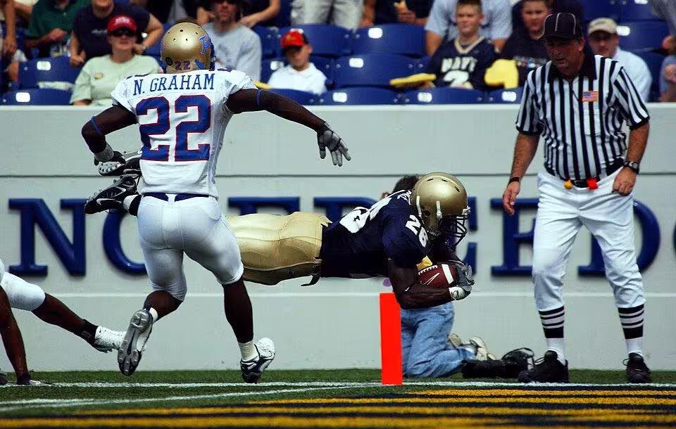 Full color game action photo of Navy slot back Shun White, #26 scores Navy's first touchdown on a 26-yard run in the second quarter. Navy lost 24-23 against the University of Tulsa’s Golden Hurricanes in the first overtime game in Academy history.