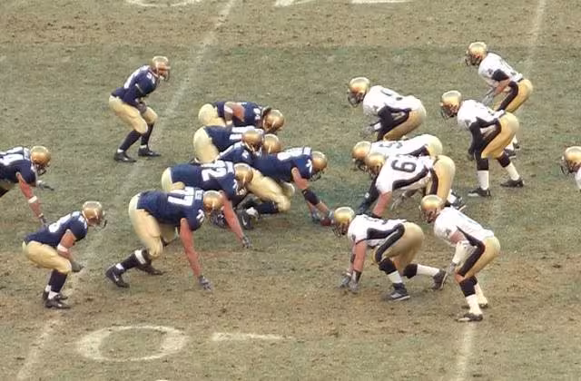 American Football, play from scrimmage, isometric press and muscular preload.jpg Both the offense and defense crouch prior to beginning the play. This crouching action is a form of isometric press which preloads the muscles. This will enable the players to drive forward more powerfully when the snap is made and they engage the opposing team. This is a cropped version of a public domain photo. The original is listed on Wikimedia Commons as: File:Football play from scrimmage.jpg RickyBennison
