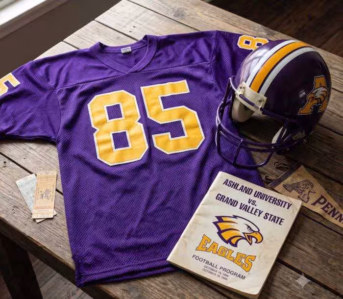 AI-generated purple jersey 85 on a wooden table with a helmet and period example of a program