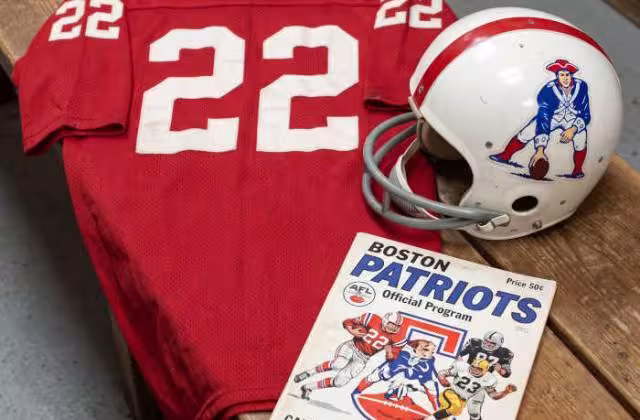 Gemini AI generated image of a 1960s-era red American football jersey 22, without a name on it, and a matching period-correct helmet, the program cover appropriate to the era and team.
