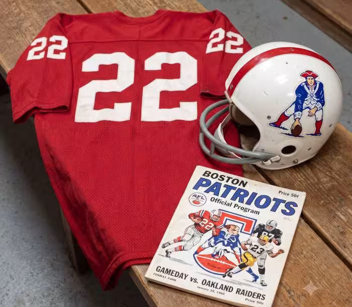 Gemini AI generated image of a 1960s-era red American football jersey 22, without a name on it, and a matching period-correct helmet, the program cover appropriate to the era and team.