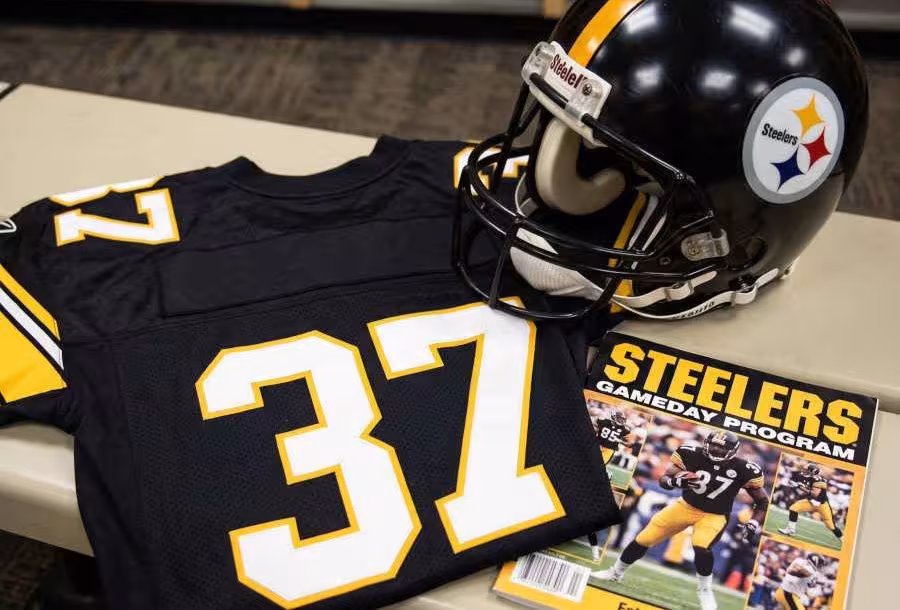 AI-generated black jersey 37 on a wooden table with a matching helmet and period example of a program