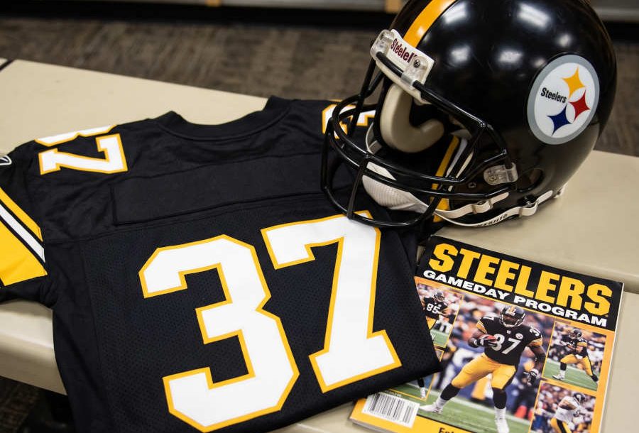 AI-generated black jersey 37 on a wooden table with a matching helmet and period example of a program