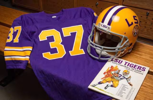 Gemini AI generated image of a 1970s-era purplish-blue American football jersey 37, without a name on it, and a matching period-correct helmet, the program cover appropriate to the era and team.