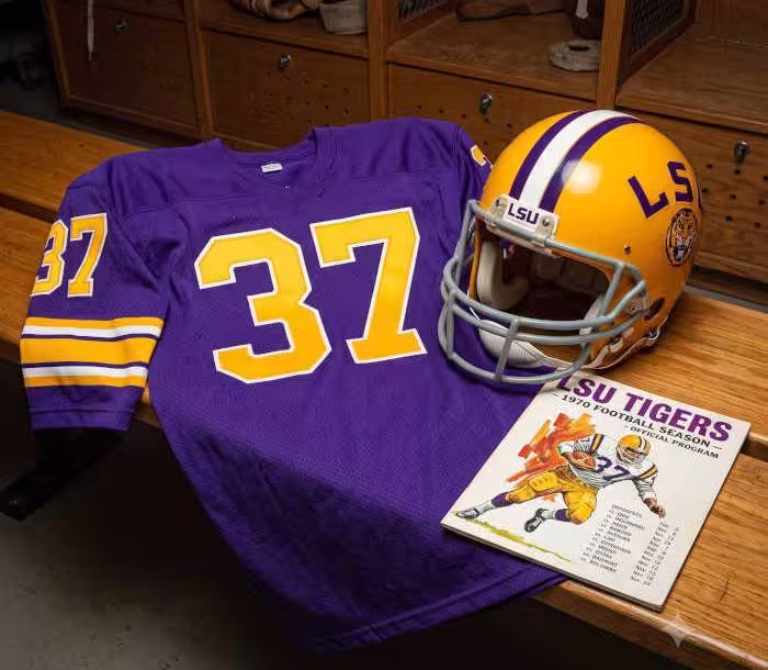 Gemini AI generated image of a 1970s-era purplish-blue American football jersey 37, without a name on it, and a matching period-correct helmet, the program cover appropriate to the era and team.