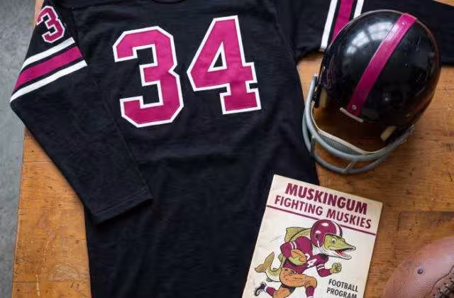 AI-generated black jersey 34 on a wooden table with a matching helmet and period example of a program