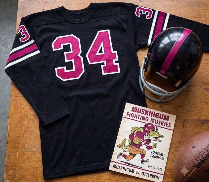 AI-generated black jersey 34 on a wooden table with a matching helmet and period example of a program