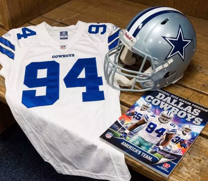 Gemini AI generated image of a 2010s-era white American football jersey 94, without a name on it, and a matching period-correct helmet, the program cover appropriate to the era and team.