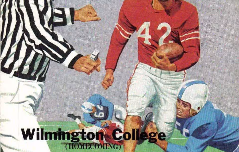 Full color artists rendering of an American football player in a red jersey running with the ball avoiding a defender clad in blue as part of Cover of a football program dated 1958.
