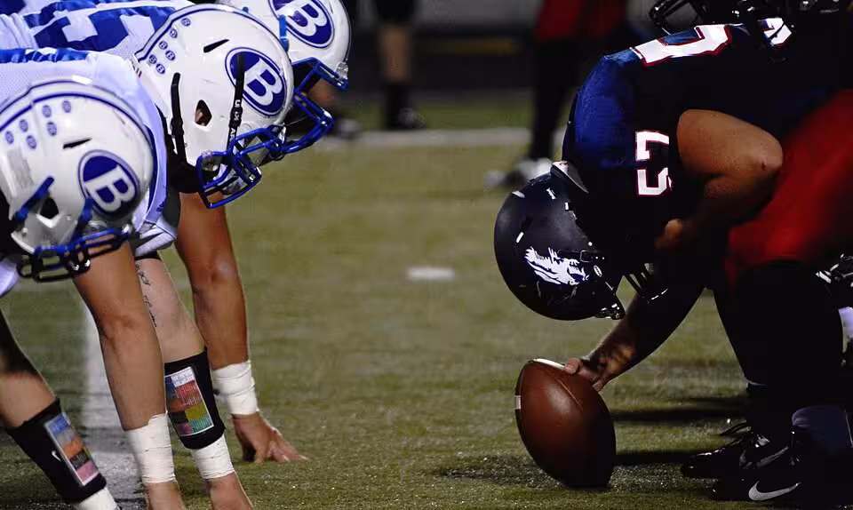 Full color image pre-snap down the line of scrimmage for A December 14, 2015 photo by Nathan Shively of Football players on field (Unsplash)