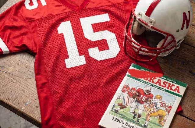 AI-generated red jersey 15 on a wooden table with a leather helmet and period example of a program