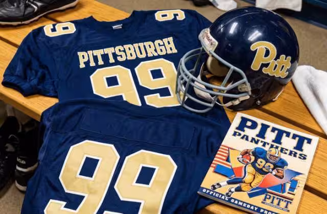 Gemini AI generated image of a 1980s-era blue American football jersey 99, without a name on it, and a matching period-correct helmet, the program cover appropriate to the era and team.