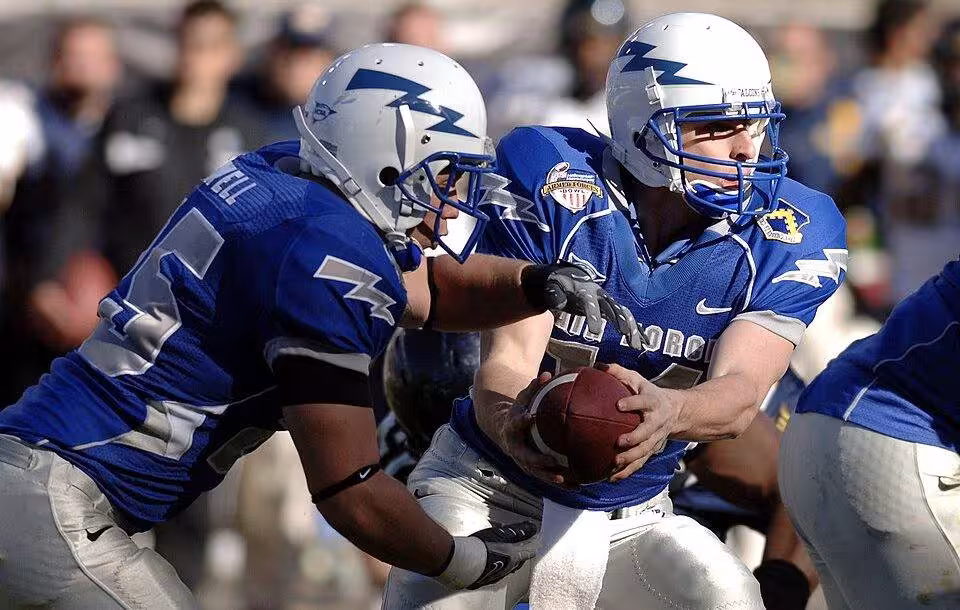 Full color game action image of U.S. Air Force Academy junior quarterback Shea Smith hands off to junior fullback Todd Newell during the Bell Helicopter Armed Forces Bowl at Amon G. Carter Stadium in Fort Worth, Texas, Dec. 31, 2007. The academy lost 42-36 against the California Golden Bears in their first bowl appearance since 2002 before a bowl record 40,905 fans and a national television audience on ESPN. ID: 071231-F-0558K-017 via Mike Kaplan