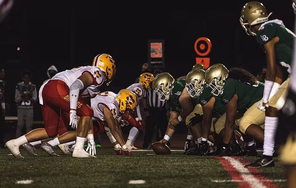 Full color game action at the line of scrimmage, presnap of Football players from the Mission Viejo and Long Beach Polytechnic High School football teams prepare to snap the ball during a football game at the Veterans Memorial Stadium, Long Beach, California, Sept. 3, 2021. The Great American Rivalry Series, presented by the United States Marine Corps, features some of the longest-running and most tradition-filled rivalries in high school football across the nation. (U.S. Marine Corps photo by Sgt. Christian Cachola)