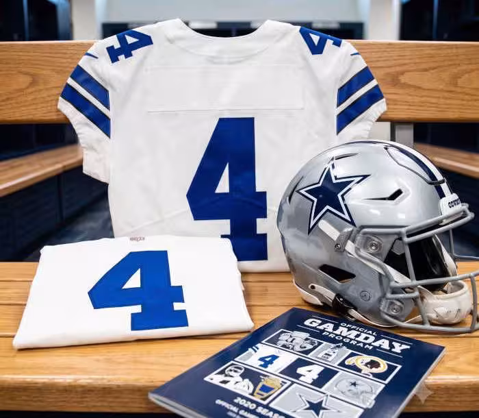 Gemini AI generated image of a 2020s-era white American football jersey 4, without a name on it, and a matching period-correct helmet, the program cover appropriate to the era and team.