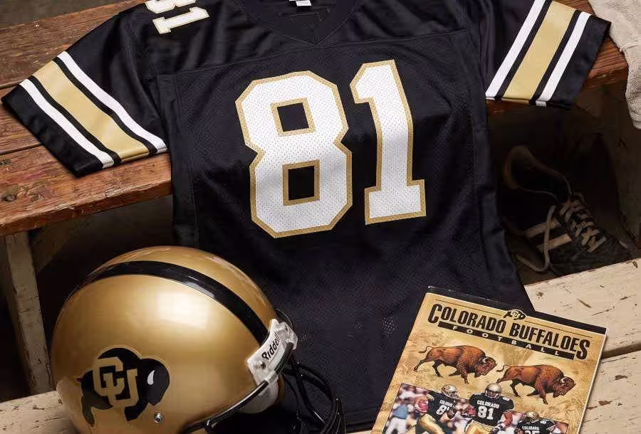 AI-generated black jersey 81 on a wooden table with a black "Buffalo" emblem on a gold helmet and period example of a program